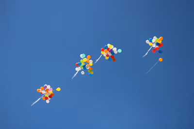 Colorful balloons flying in a blue sky